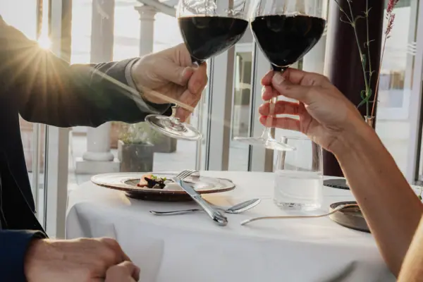 Una coppia con in mano dei bicchieri da vino.