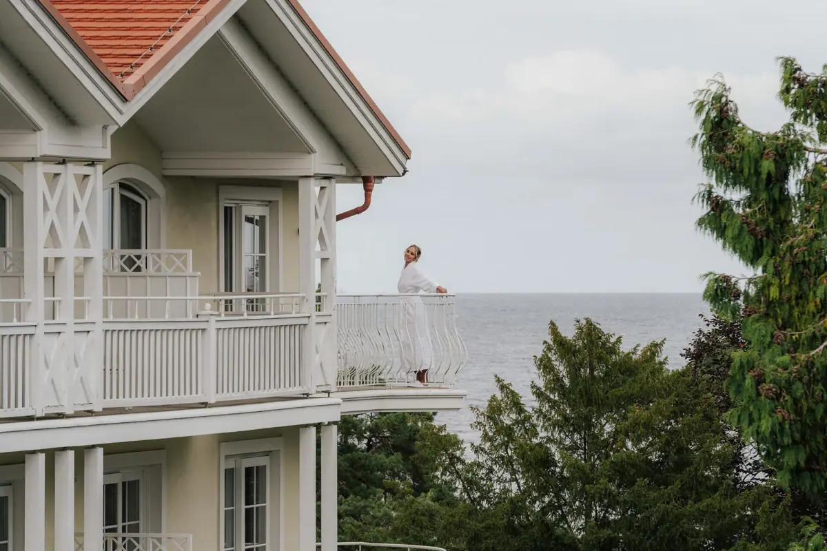 Una donna è in piedi su un balcone affacciato su uno specchio d'acqua.