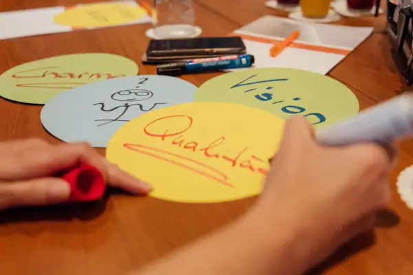 Eine Person schreibt mit einem Stift auf einem runden Papier.