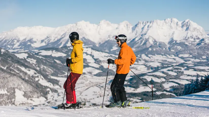 Due persone sciando su una montagna innevata.