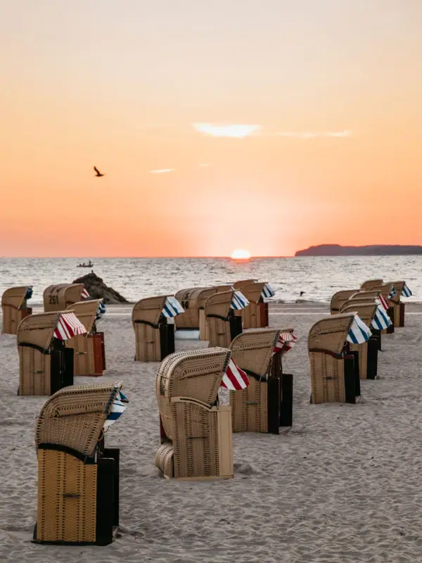 Strandkörbe Eine Gruppe von Stühlen am Strand.