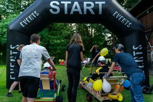 Un gruppo di persone in un campo con un arco nero.
