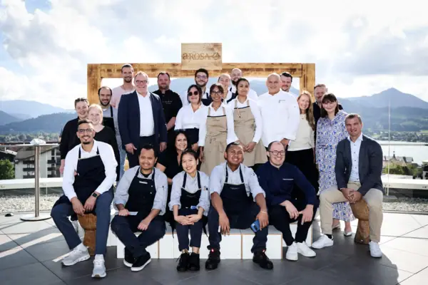 Un gruppo di persone posa sorridente per una foto all'aperto.