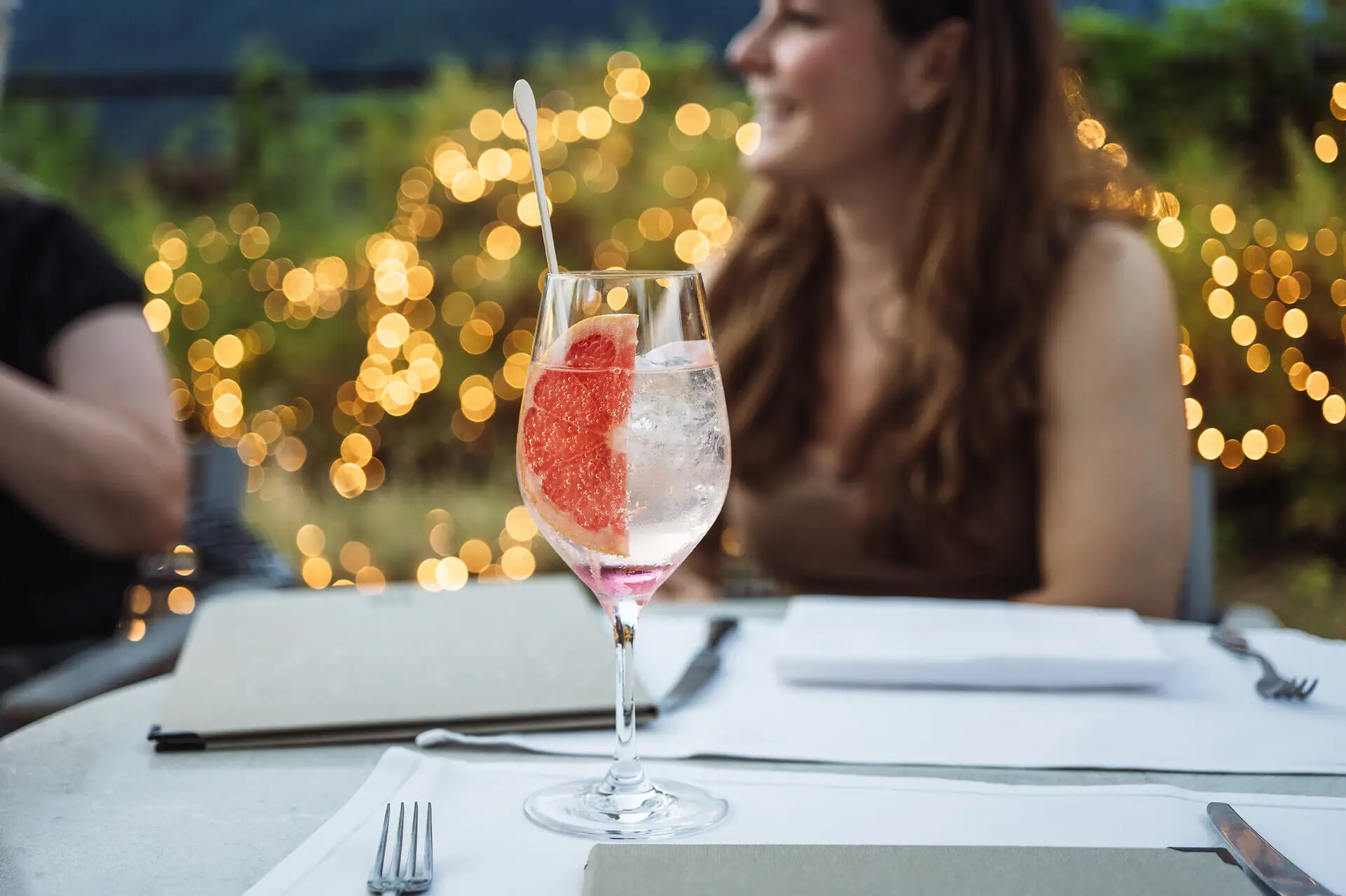 Trattoria all’aperto all’Hotel A-ROSA Lago di Garda con cocktail, luci soffuse e atmosfera romantica