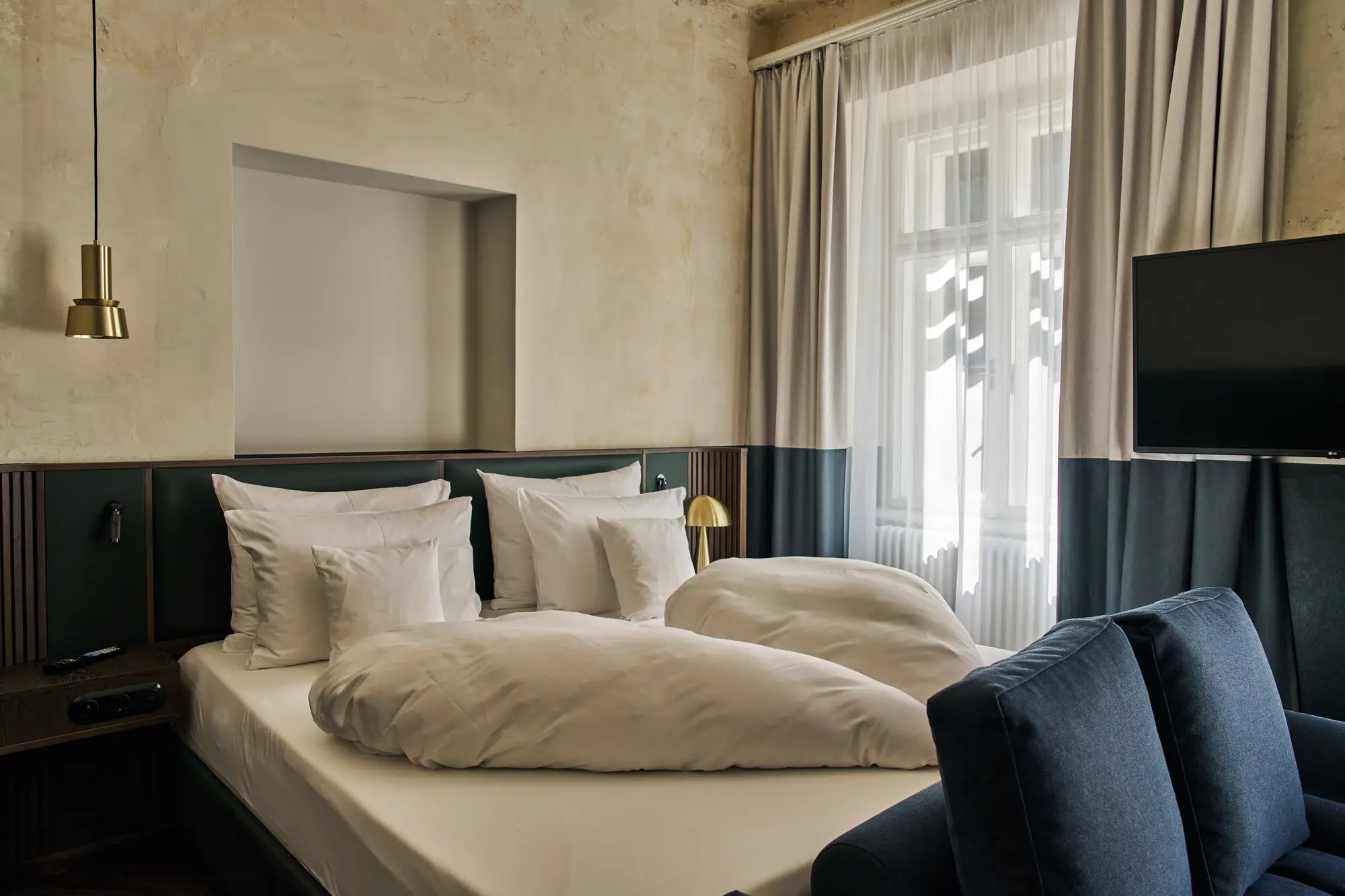 Letto con cuscini e lampada in una stanza.