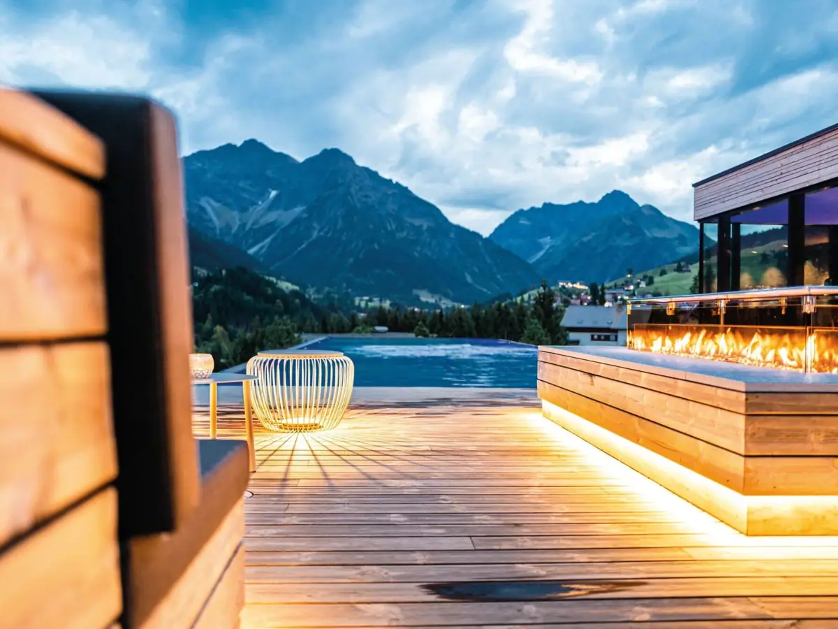 Una terrazza con fuoco e piscina sullo sfondo.