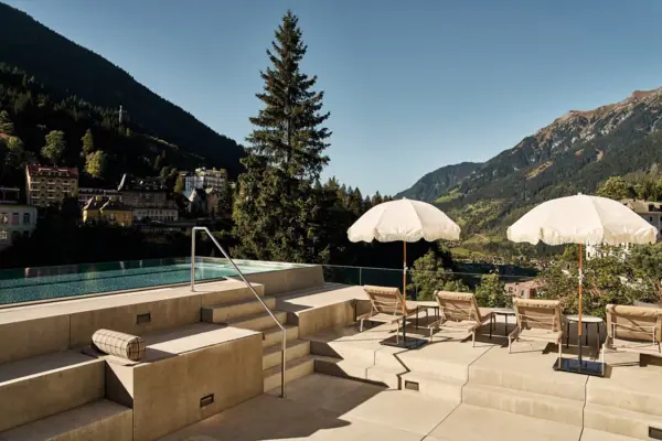 Una piscina con ombrelloni e sedie a sdraio nelle giornate di sole.