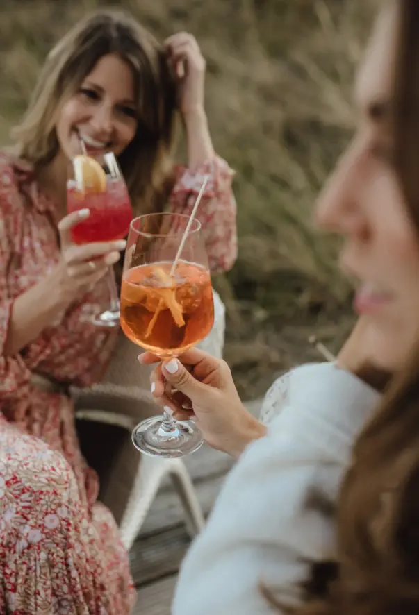 Gruppo di donne che tengono dei drink all'aperto.