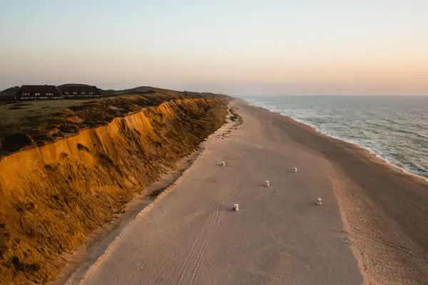 La scogliera rossa di Sylt con la spiaggia sabbiosa e il mare sullo sfondo.