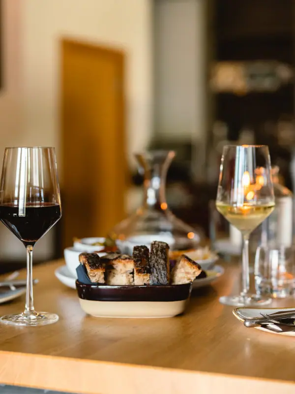 Un tavolo con cibo e bicchieri di vino.