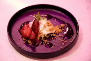 Un piatto da dessert guarnito con frutta e granella.