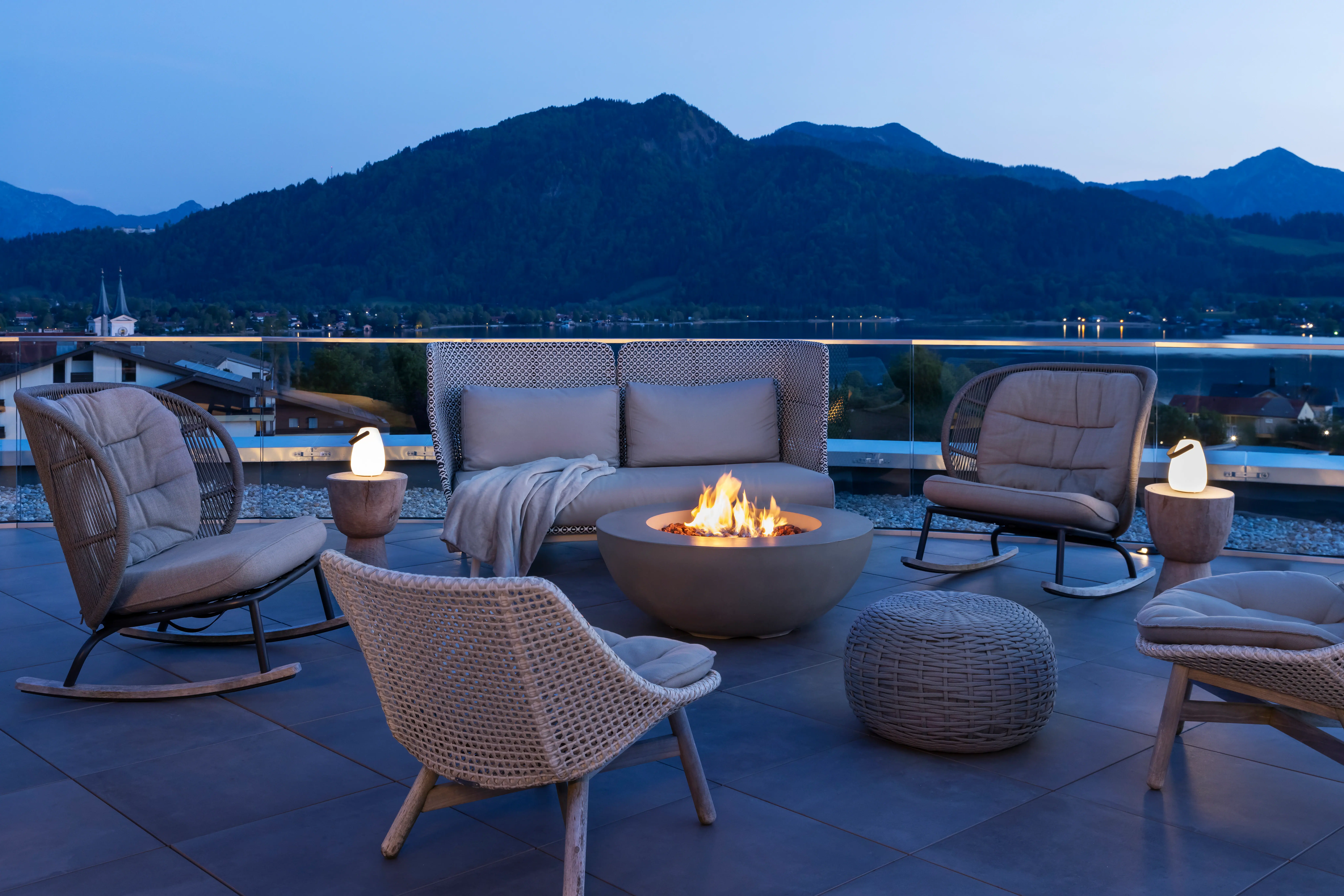 Una terrazza con un focolare e delle sedie su un balcone.