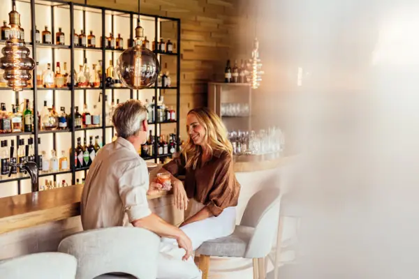 Un uomo e una donna sono seduti al bancone di un bar.