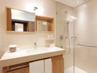 Un bagno con lavabo e cabina doccia vetrata.