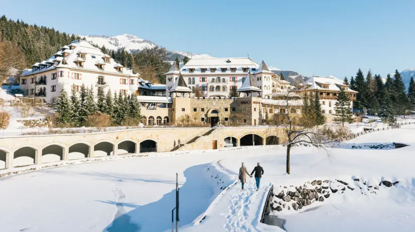 Una coppia cammina sulla neve in un paesaggio invernale.