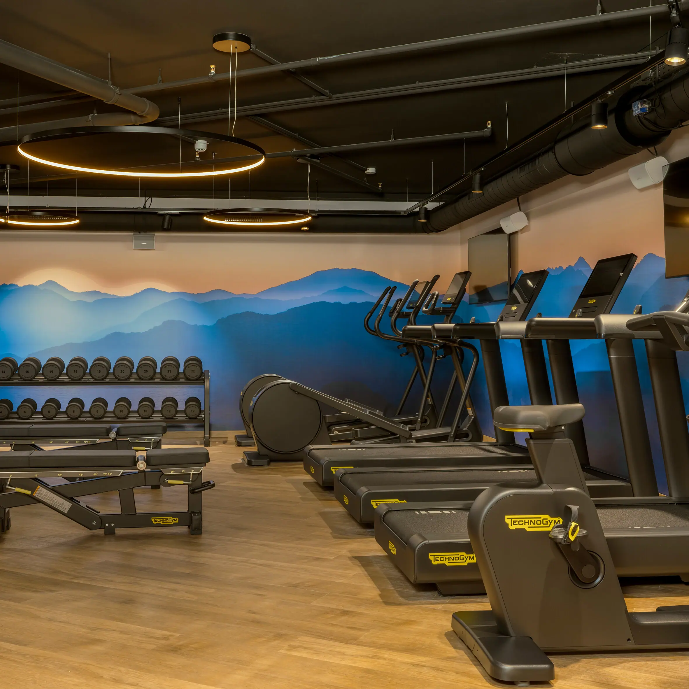 Una palestra con tapis roulant e attrezzature per l'allenamento.