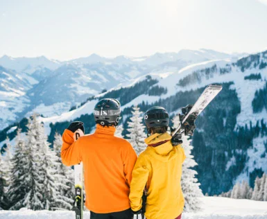 Due persone con sci su una montagna innevata.