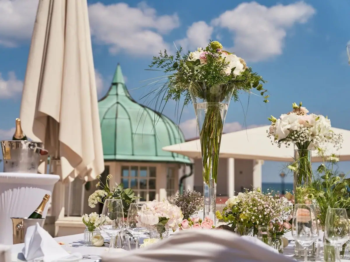 Ein mit Blumen und Gläsern gedeckter Tisch im Freien.