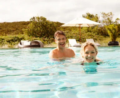 Un uomo e una donna in una piscina all'aperto.