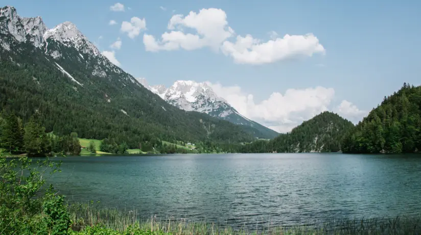 Lago circondato da montagne con cielo nuvoloso.