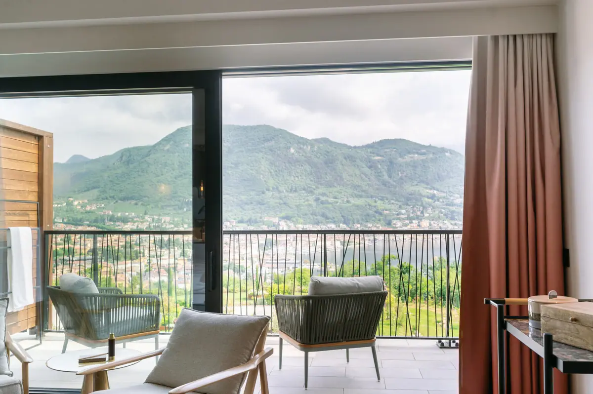 Camere all’A-ROSA Lago di Garda Una camera con balcone e vista sulle montagne e sugli alberi.