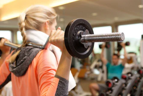 Donna che solleva pesi in una palestra.