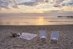Una spiaggia con sedie e coperte.