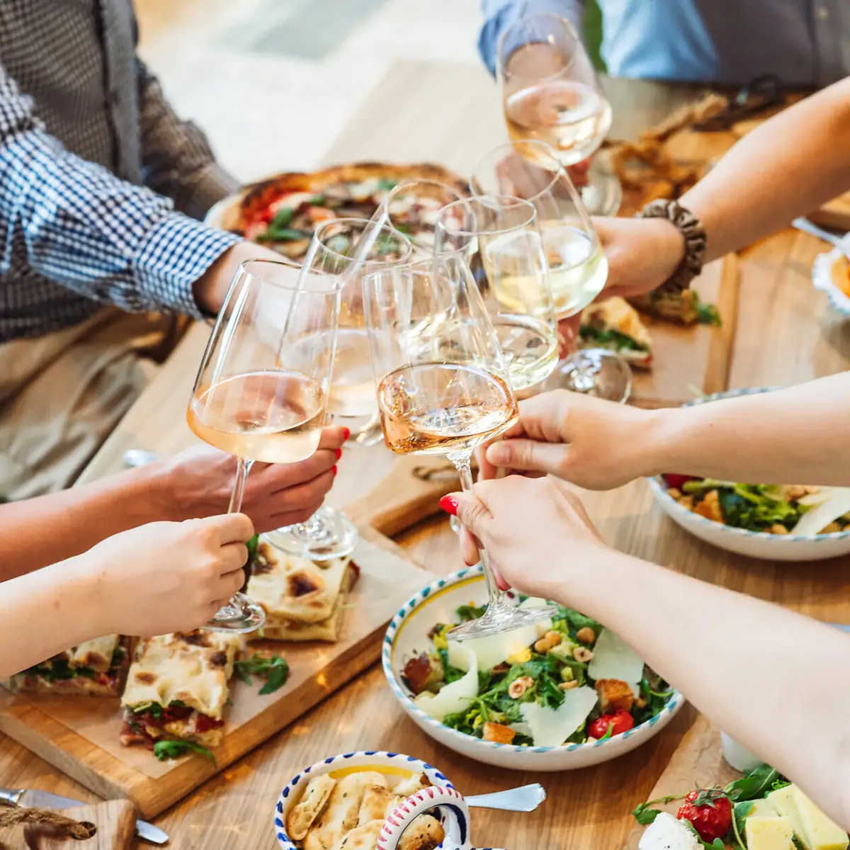 Un gruppo di persone che brindano con bicchieri di vino.