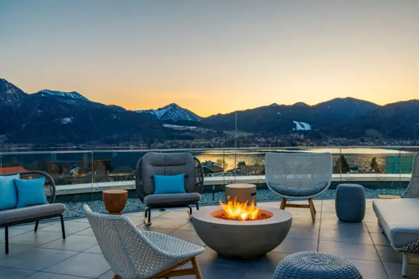 A-ROSA Tegernsee NIBar Focolare con sedie e vista sulle montagne sullo sfondo