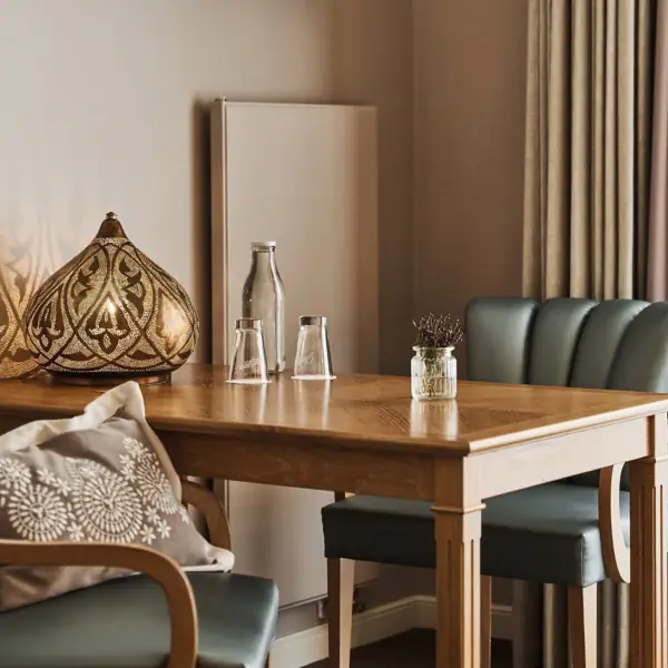 Ein Tisch mit einer Lampe und Stühlen.