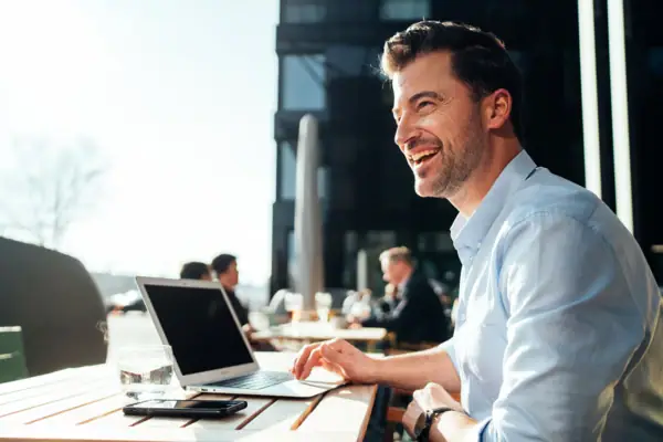 Un uomo seduto a un tavolo con un laptop.