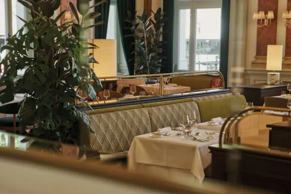 Ristorante con tavoli e sedie, albero di Natale e finestre.