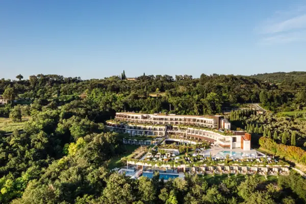 A-ROSA Hotel am Gardasee Ein Gebäude mit einem Pool, umgeben von Bäumen.