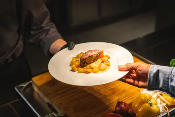 Eine Person hält einen Teller mit Essen.