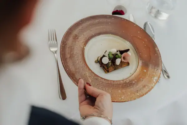 Una mano regge un piatto di cibo.