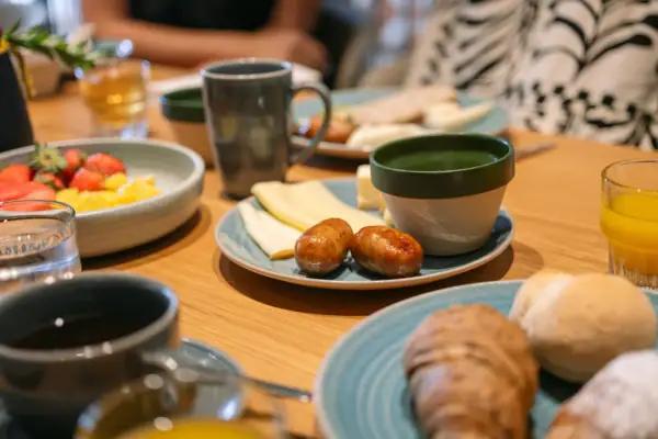 Tavolo apparecchiato con piatti di cibo e tazze di caffè.