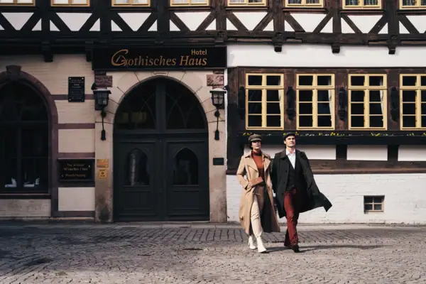 Ein Mann und eine Frau gehen vor einem Gebäude spazieren.