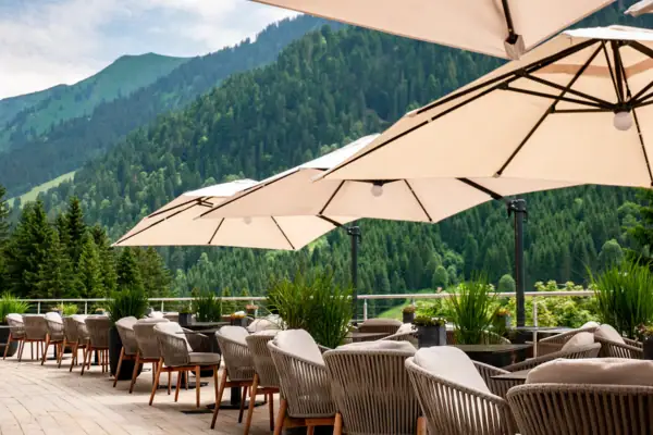 Eine Gruppe von Stühlen und Sonnenschirmen auf einer Terrasse.