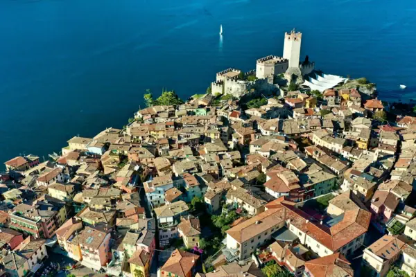 Malcesine Foto aerea di una città con un castello ai margini, circondata dall'acqua.