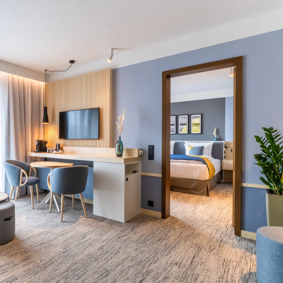 Hotelzimmer Ein Hotelzimmer mit einem Fernseher und einem Tisch.