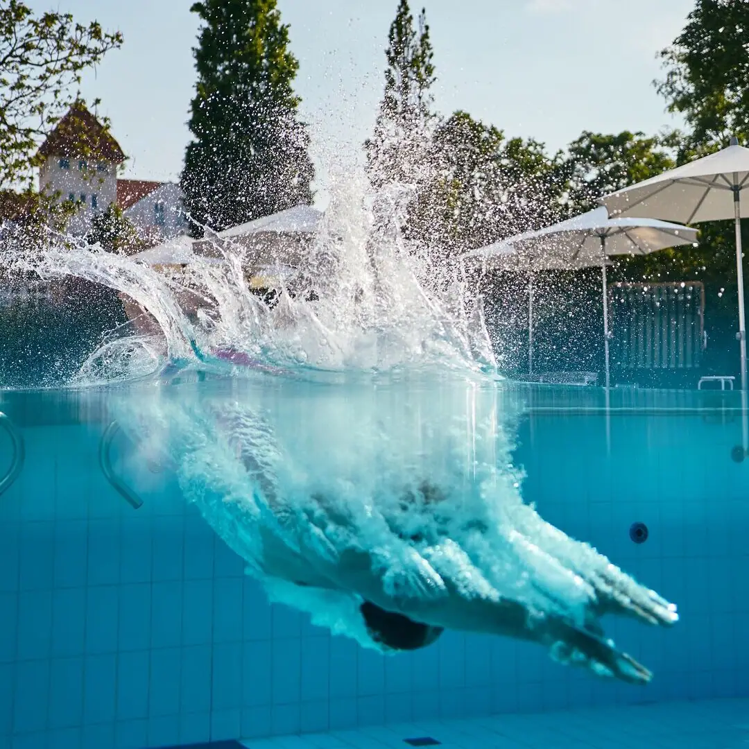 Sprung ins Wasser der beheizten Poollandschaft im A-ROSA Ostseehotel Kühlungsborn mit Blick auf die Ostseehimmel