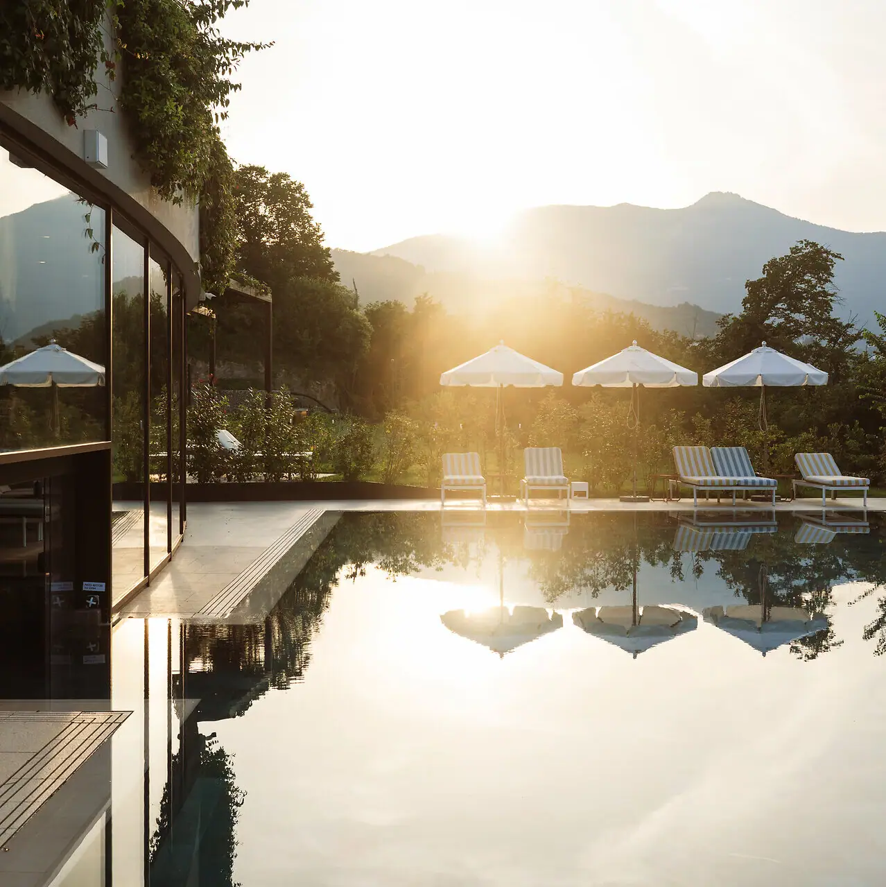 Piscina esterna dell’A-ROSA Lago di Garda con vista panoramica e lettini al sole.