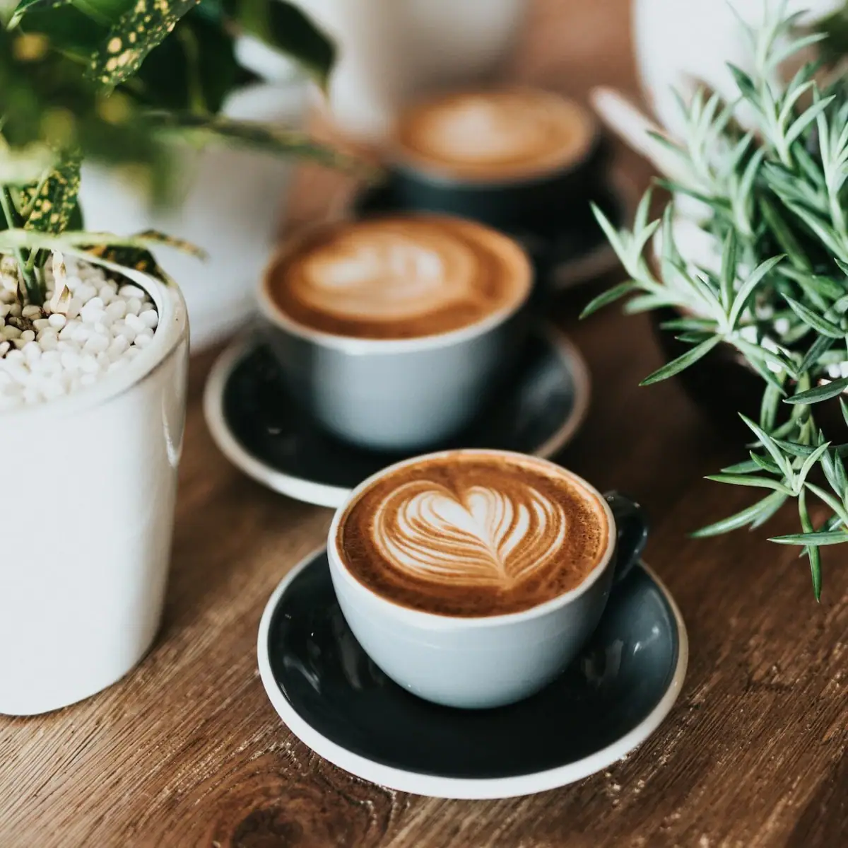 Gruppo di tazze di caffè con schiuma a forma di cuore.