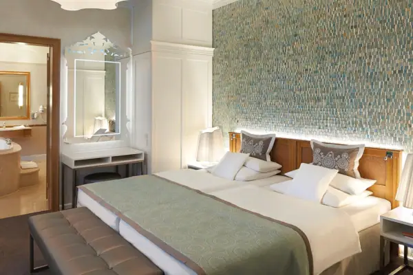 Zimmer Kurhaus Binz Ein Bett in einem Hotelzimmer mit Kissen und Bettwäsche.