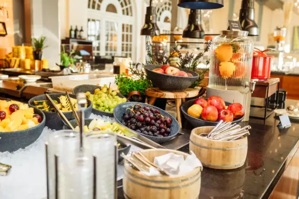 Ein Tisch mit Schalen voller Obst und Besteck.