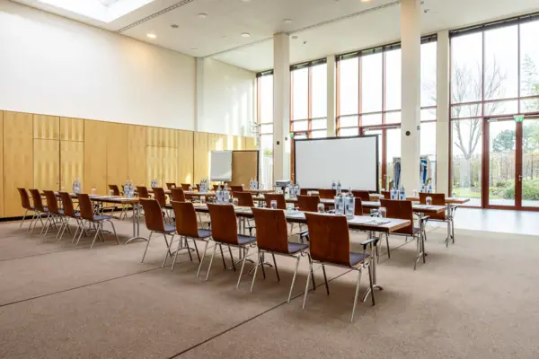 Una sala dell'A-ROSA Travemünde con tavoli e sedie.
