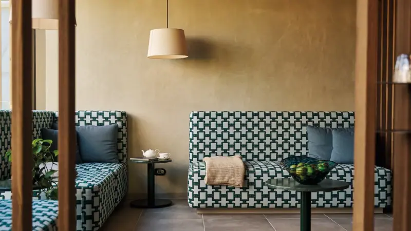 Divani e tavolo in una stanza con vaso e lampada.