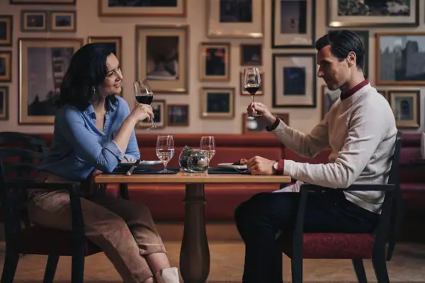 Restaurant Gothisches Haus Ein Mann und eine Frau sitzen an einem Tisch mit Weingläsern.