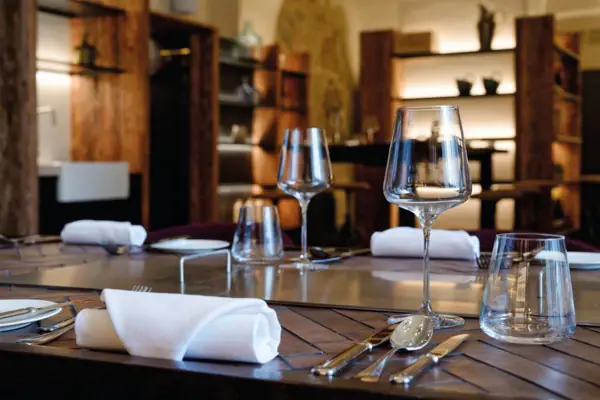 Tavolo apparecchiato con bicchieri da vino e posate.