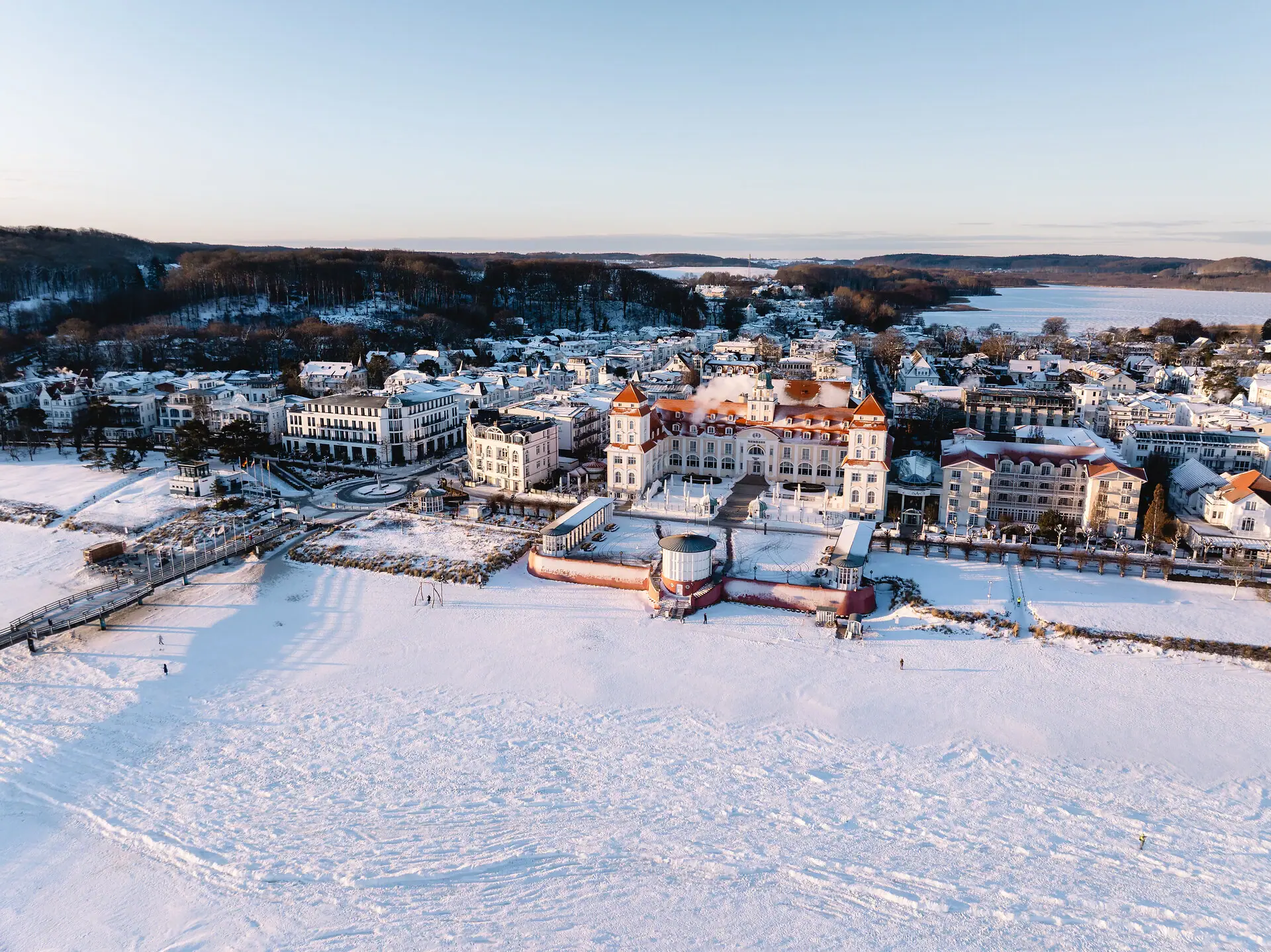 Città innevata con edifici e uno specchio d'acqua in inverno.